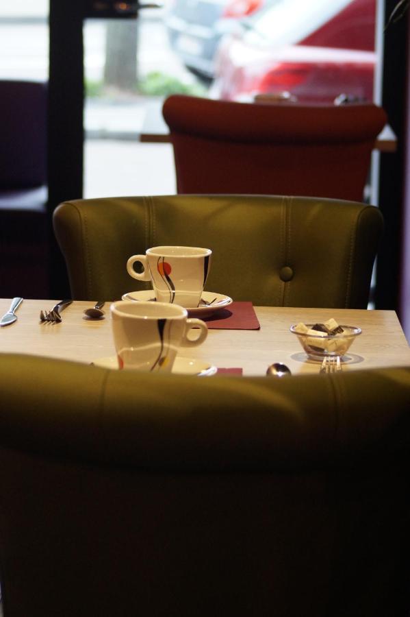 Two white patterned coffee cups sit at dog-friendly Hôtel Des Quatrans in Caen.