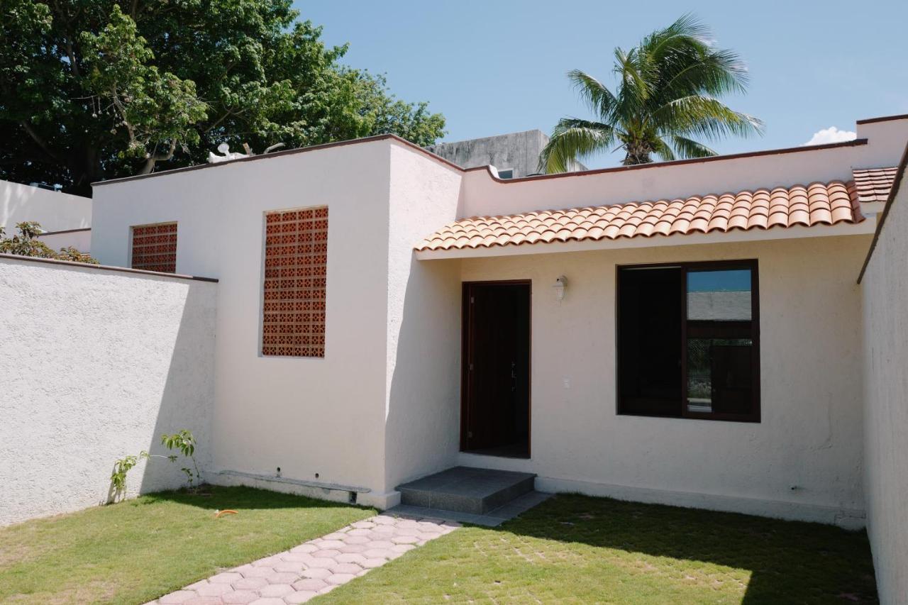 White house with terracotta roof and brown door sits at pet-friendly Villas La Ceiba in Playa del Carmen.