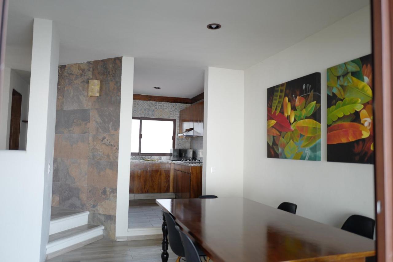 Brown wooden dining table with black chairs sits at pet-friendly Villas La Ceiba in Playa del Carmen.