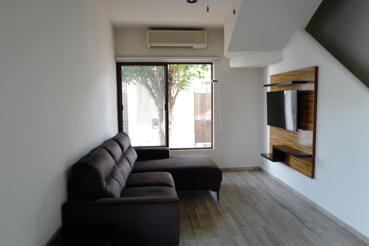 Dark brown upholstered sectional sofa sits at dog-friendly Villas La Ceiba in Playa del Carmen.