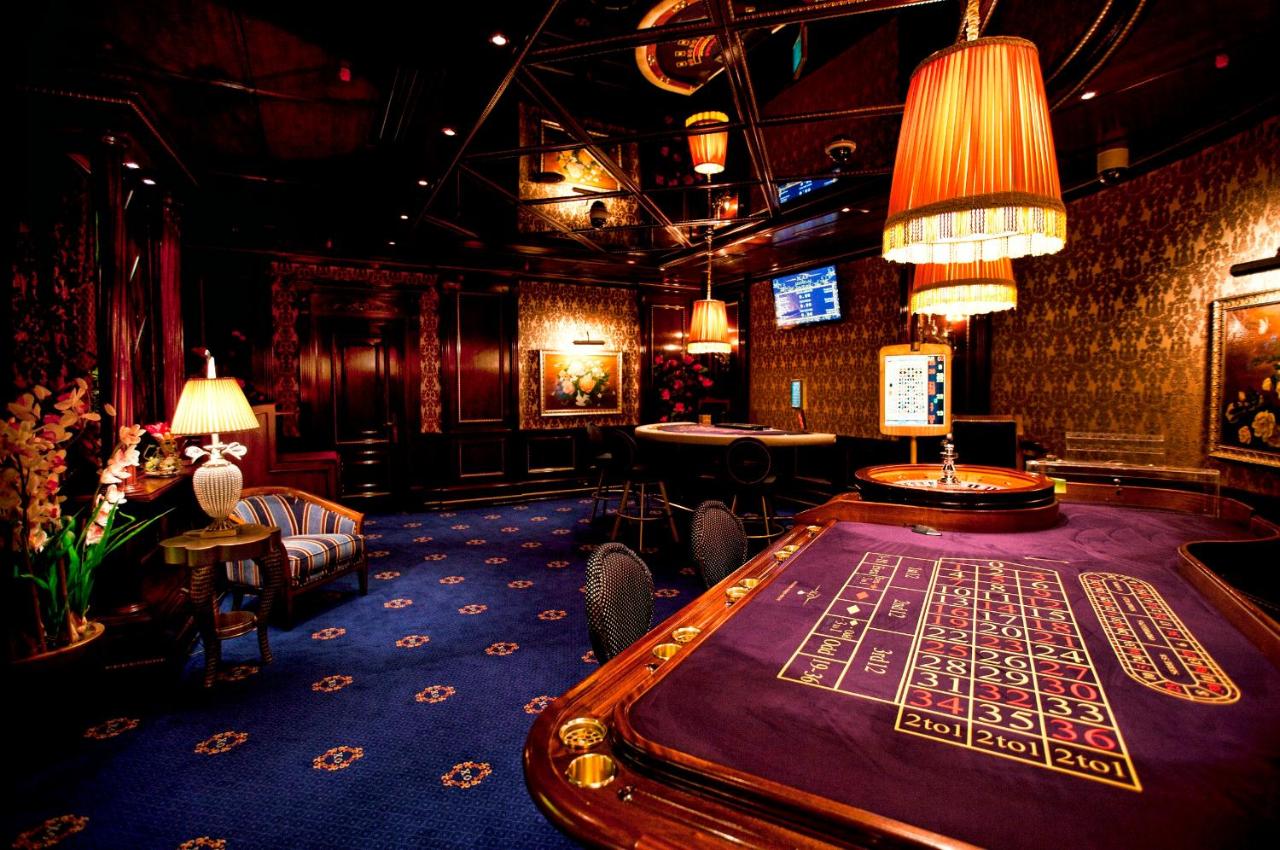 Purple-felt roulette table with wooden trim sits at dog-friendly Multi Grand Pharaon Hotel in Agveran.