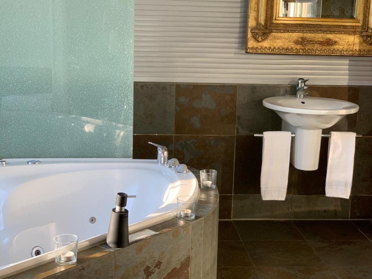 Habitación con cama extragrande, bañera de hidromasaje y baño con TV