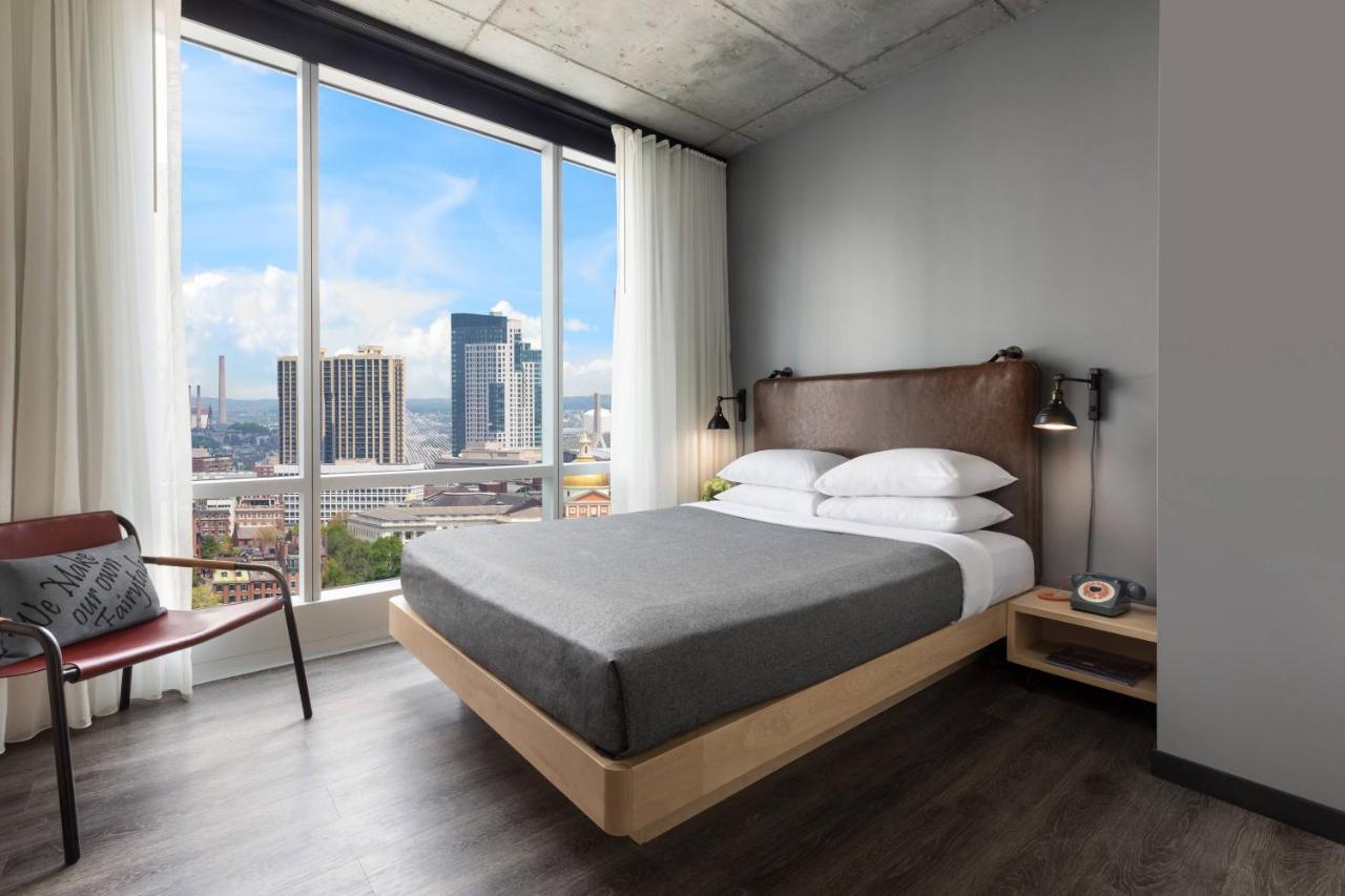 Zimmer Center Stage mit Queensize-Bett und Blick auf die Stadt