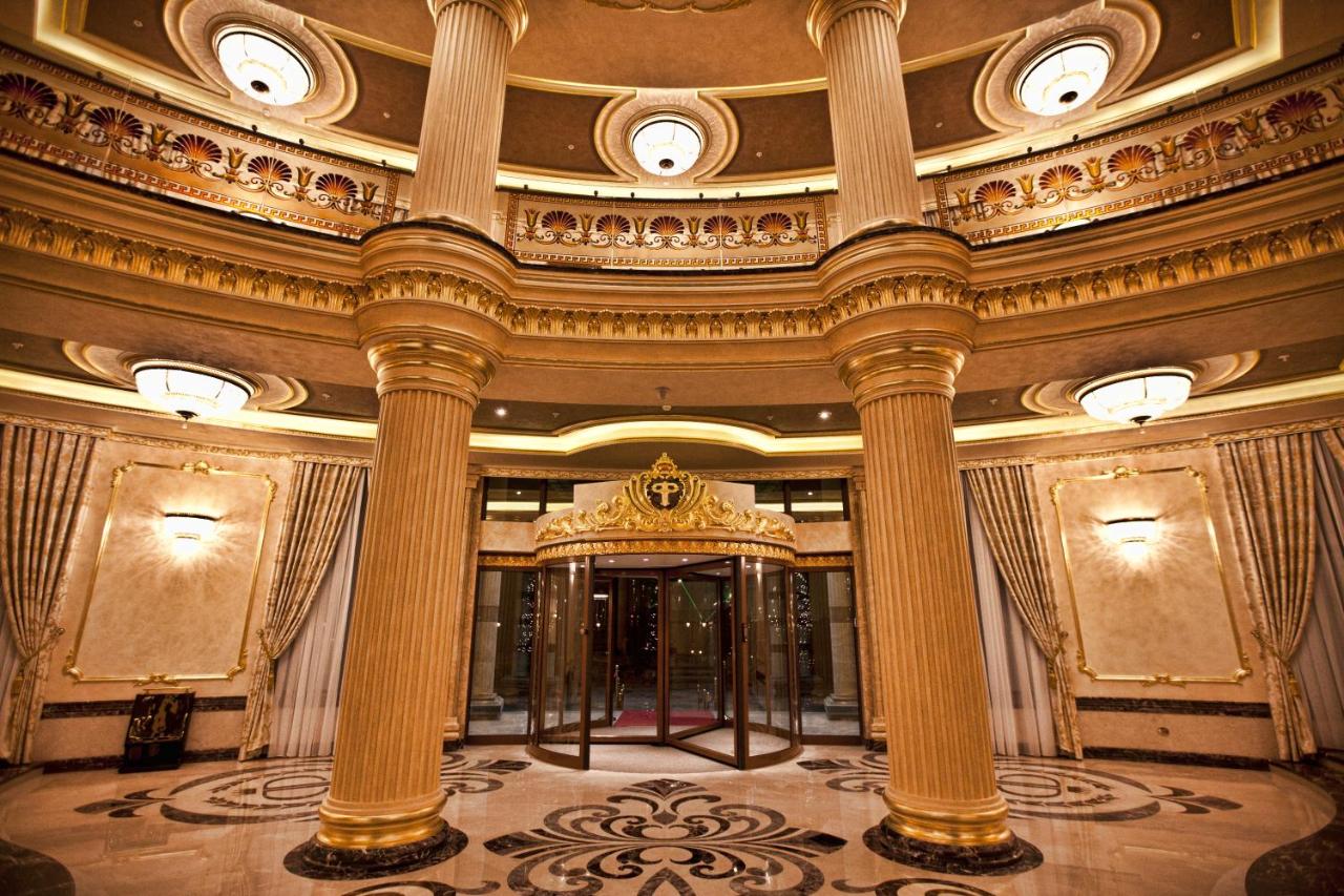 Two tall gold columns frame a revolving glass door at dog-friendly Multi Grand Pharaon Hotel in Agveran.