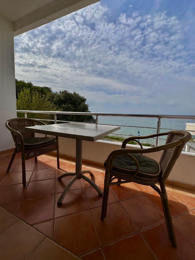 Brown wicker chairs with green cushions sit beside a table at dog-friendly Casa Mila Apartments & Bungalows in Ulcinj.