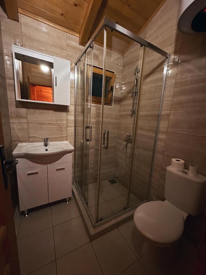 White toilet with two rolls sits beside glass shower at pet-friendly Casa Mila Apartments & Bungalows in Ulcinj.