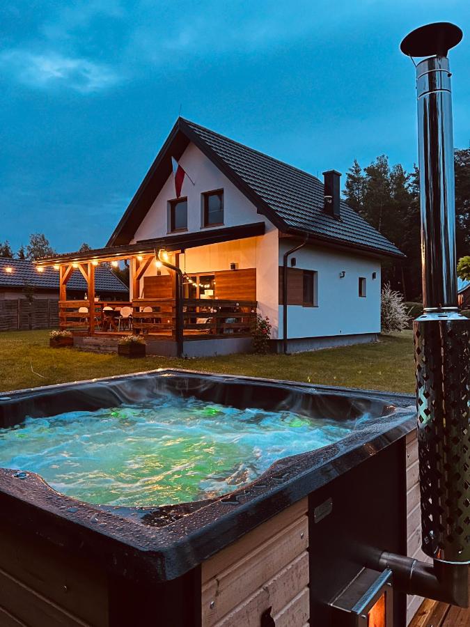 Domek z kominkiem nad jeziorem z jacuzzi ogrodowym