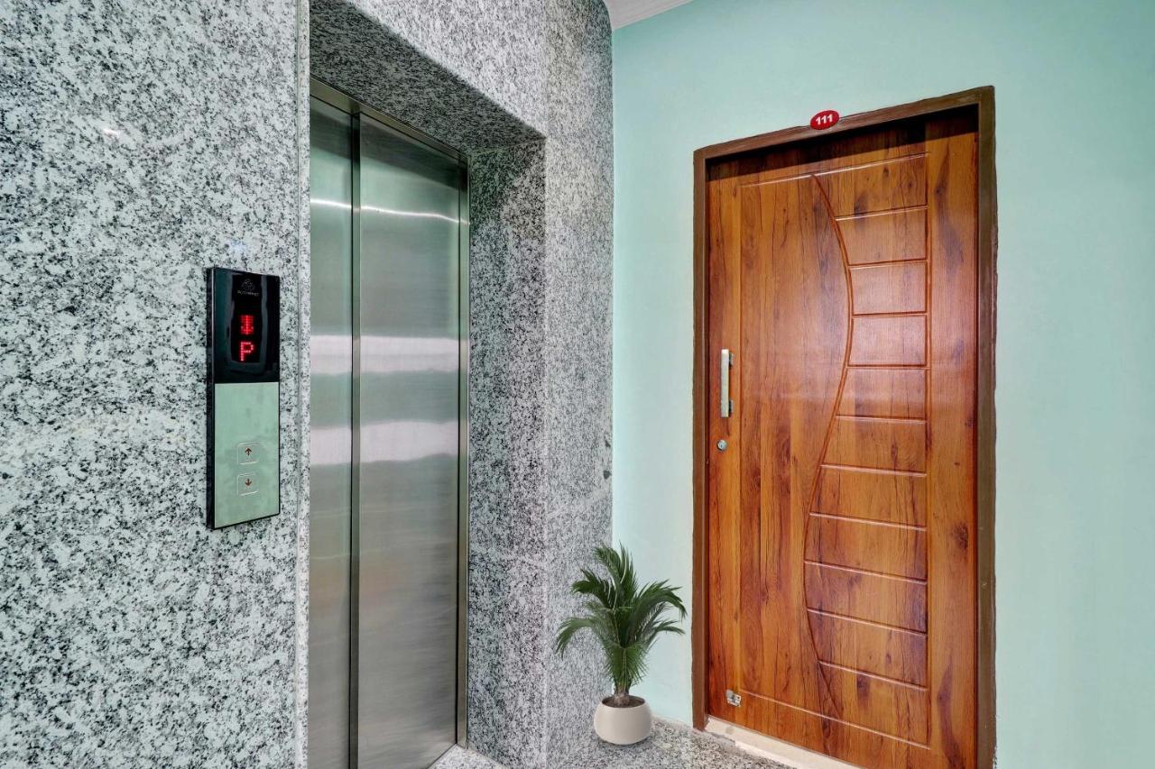 Wooden door with silver handle and red 111 plaque stands at dog-friendly The Kailash Hotel in Jhajra.