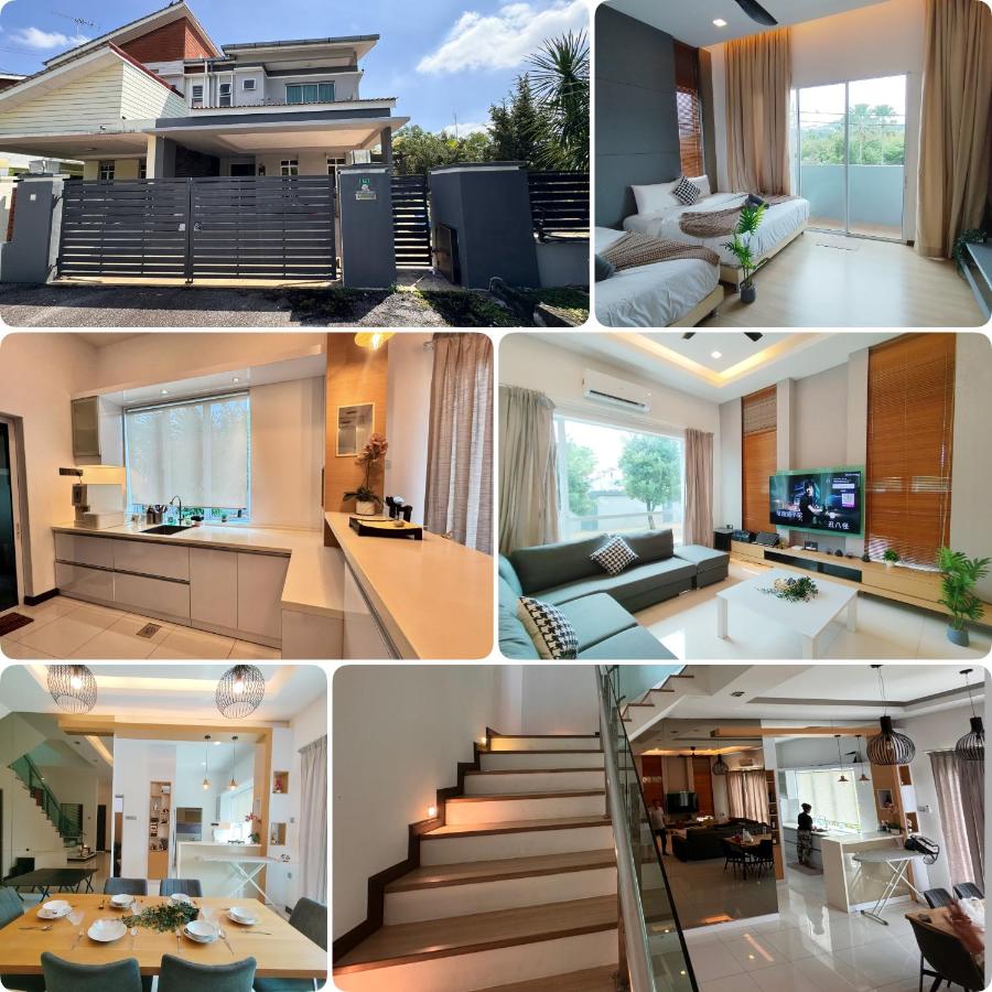 A two-story white house with gray gate stands at dog-friendly Ipoh Guesthouse by IWH Suites in Ipoh.
