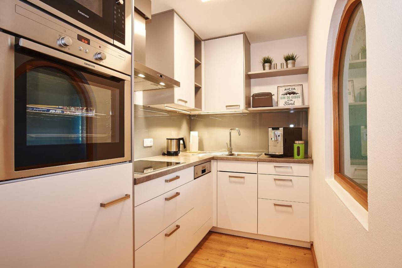 White cabinets with stainless steel handles stand at dog-friendly Gästehaus Und Ferienwohnungen Egglerlehen in Unterschönau.