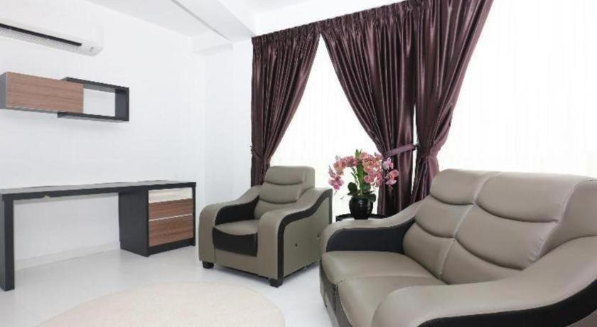 Beige leather sofa and matching armchair sit at pet-friendly OYO 89888 Dz Residence Guest House in Kota Bharu.