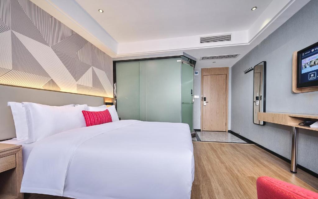 White bed with red pillow sits at dog-friendly Borrman Hotel Changsha Hunan Biological Electromechanical College in Xingsha.