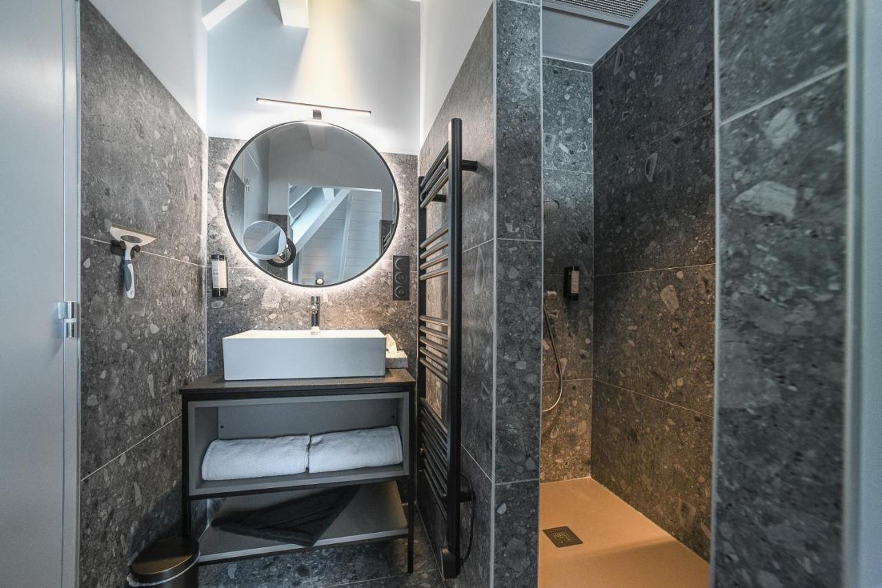 White rectangular sink sits on dark vanity at dog-friendly La Villa du Lac in Aiguebelette-le-Lac.