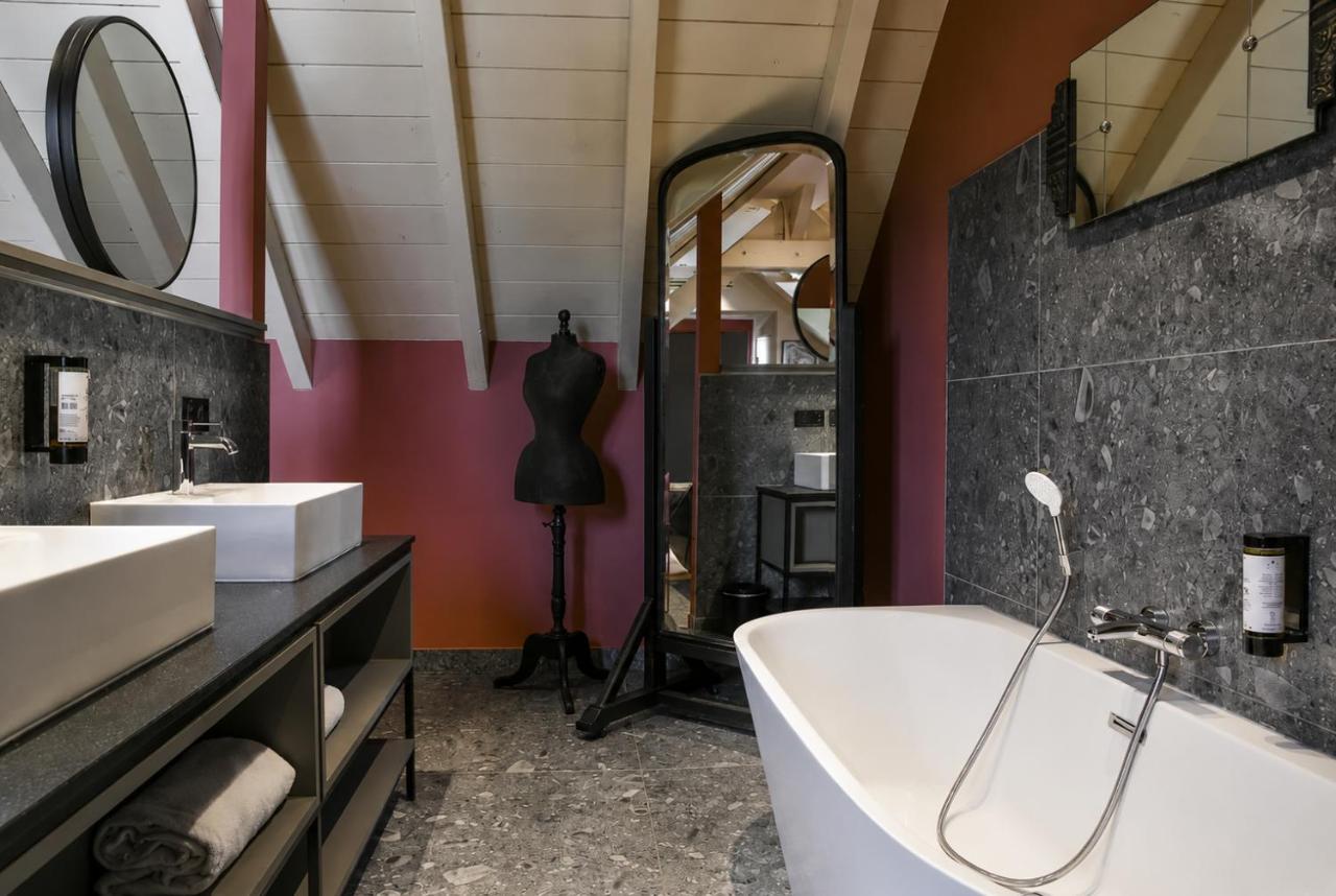 White freestanding bathtub with chrome handheld shower sits at dog-friendly La Villa du Lac in Aiguebelette-le-Lac.