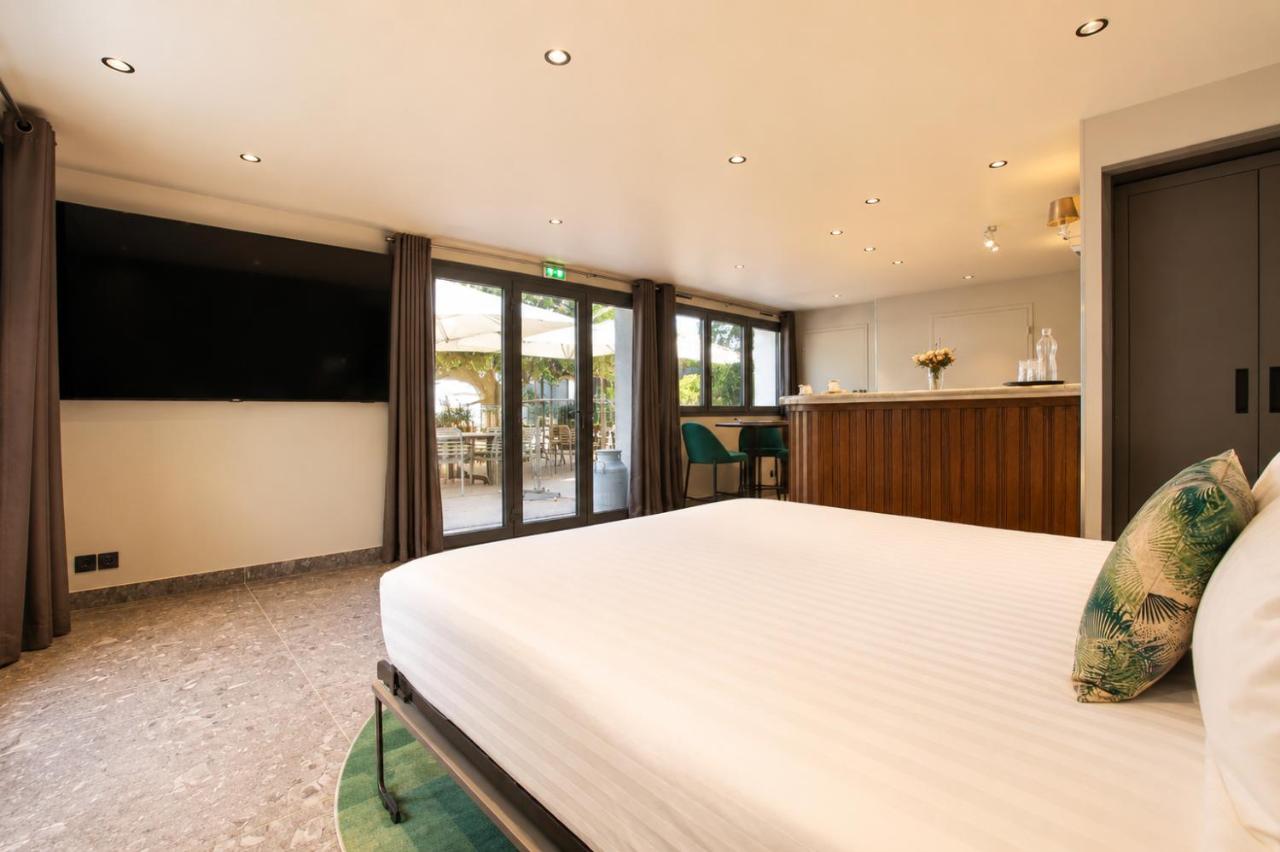 White bed with green patterned pillow sits at dog-friendly La Villa du Lac in Aiguebelette-le-Lac.