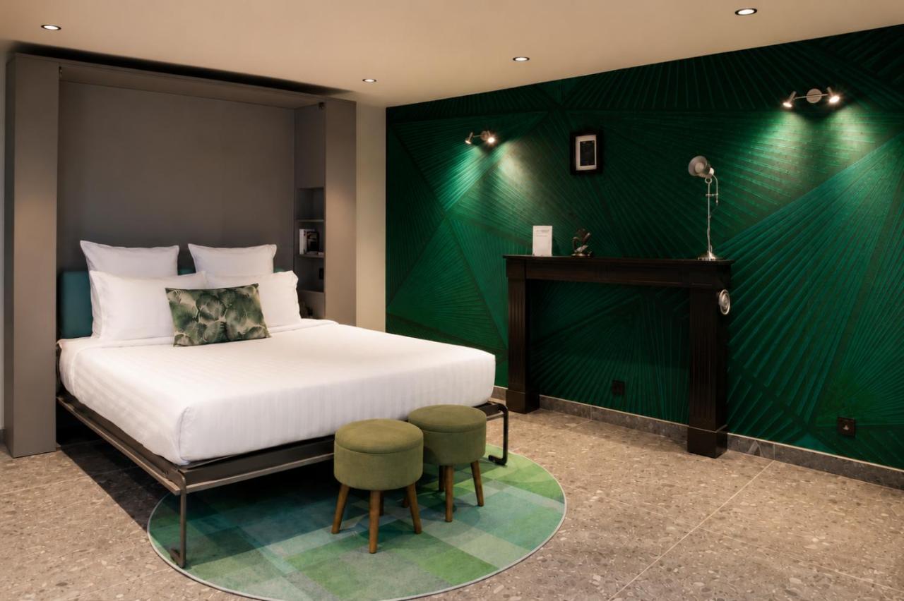 White bed with green floral pillow sits at dog-friendly La Villa du Lac in Aiguebelette-le-Lac.
