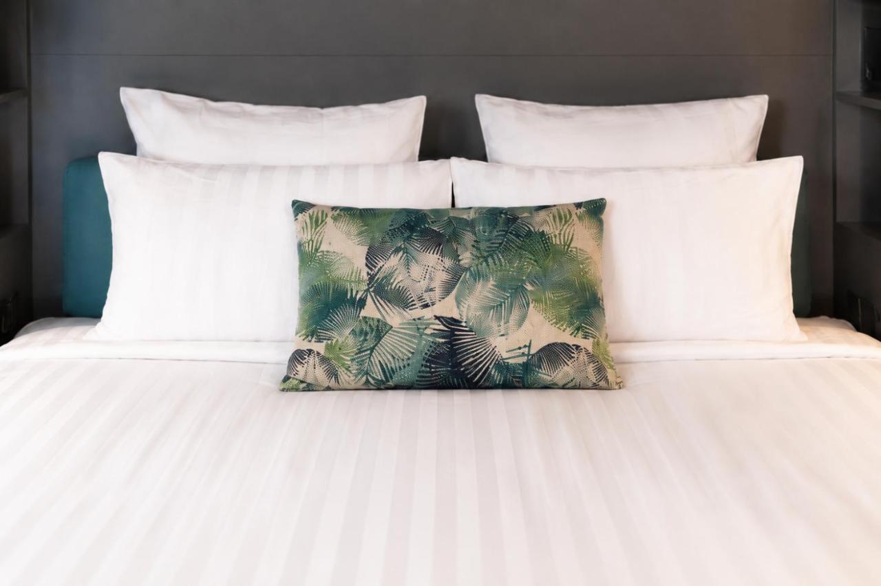 Green leaf-patterned pillow rests at dog-friendly La Villa du Lac in Aiguebelette-le-Lac.