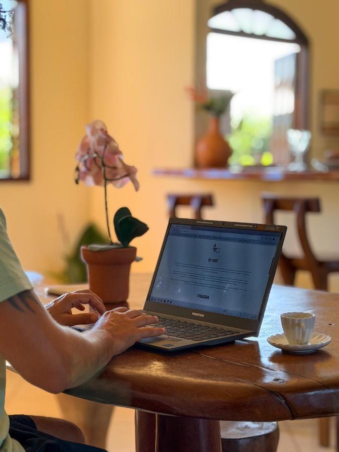 Person in light green shirt with tattoo types on laptop at dog-friendly Casa Magna in Itacare.