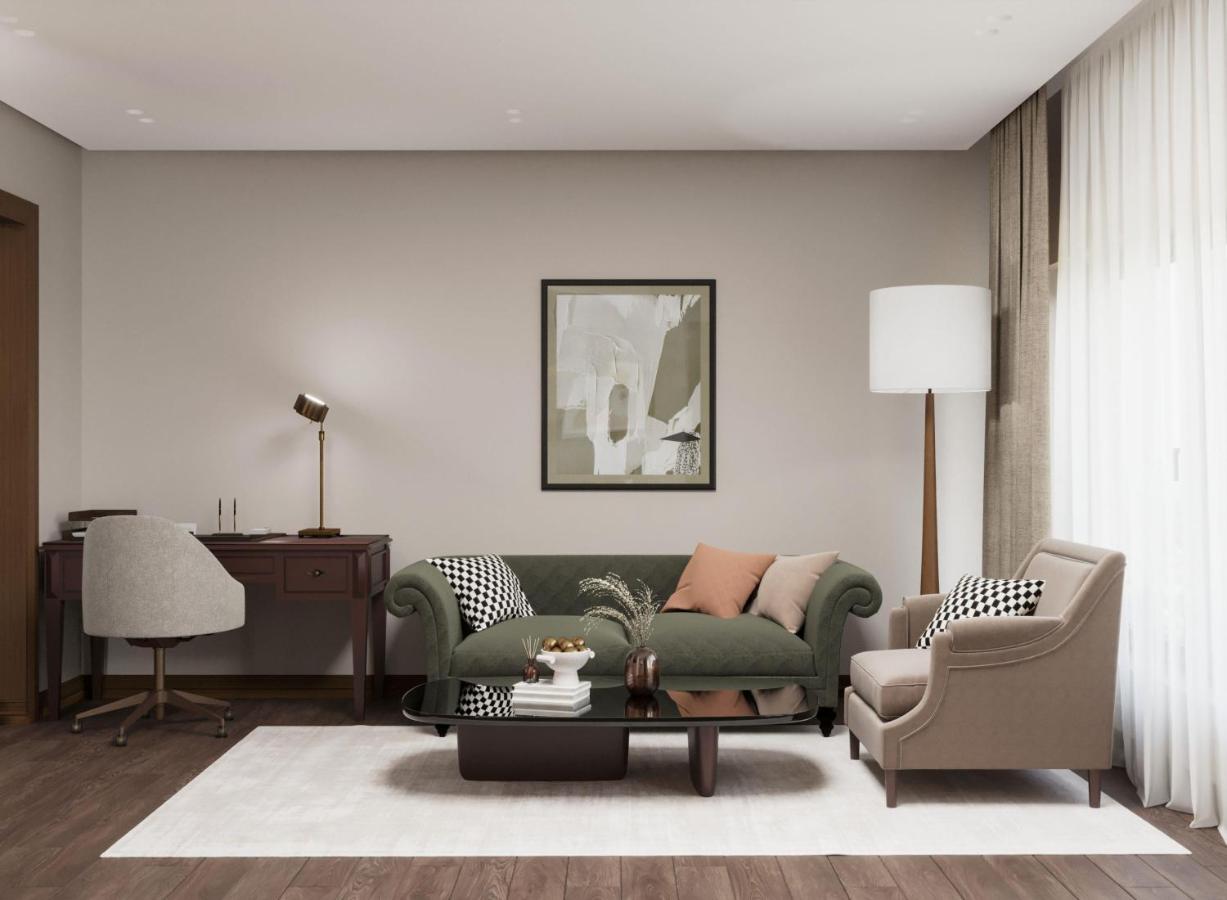 Green sofa with patterned pillow sits at dog-friendly Excelsior Hotel & Spa Baku Curio Collection by Hilton in Baku.