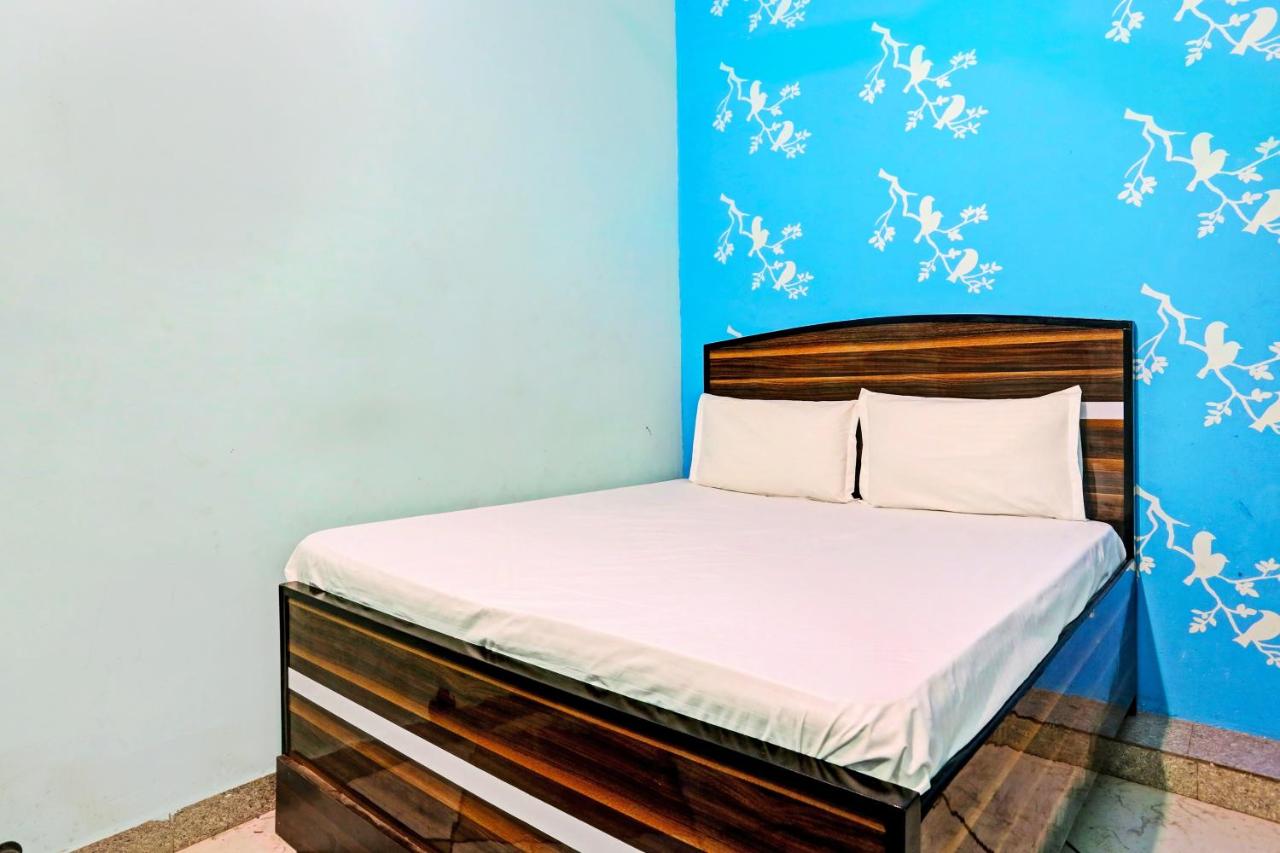 Wooden bed with white sheets and two white pillows positioned at dog-friendly Hotel the Paradise Inn in Jhajjar.