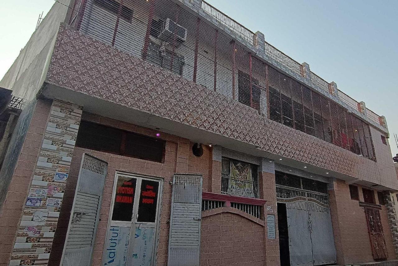 Pink patterned two-story building with metal shutters stands at dog-friendly OYO Hotel 44676 Jyotish House in Ayodhya.