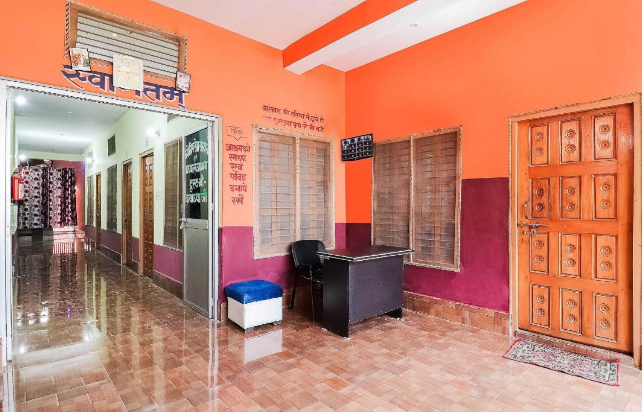 Orange and magenta painted walls with carved wooden door stand at pet-friendly OYO Hotel 44676 Jyotish House in Ayodhya.