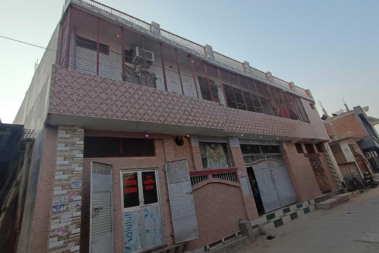 Two-story pink tiled building with metal gates stands at pet-friendly OYO Hotel 44676 Jyotish House in Ayodhya.