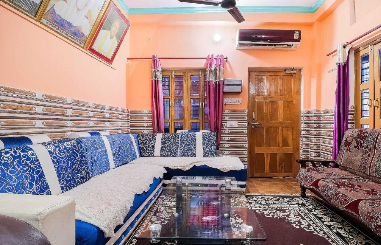 Blue-and-white upholstered sectional sofa with white throws sits at dog-friendly OYO Hotel 44676 Jyotish House in Ayodhya.