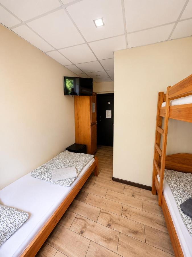 Small room with beige walls and wooden bunk bed contains a single mattress at dog-friendly Hostel Filip in Gdańsk.