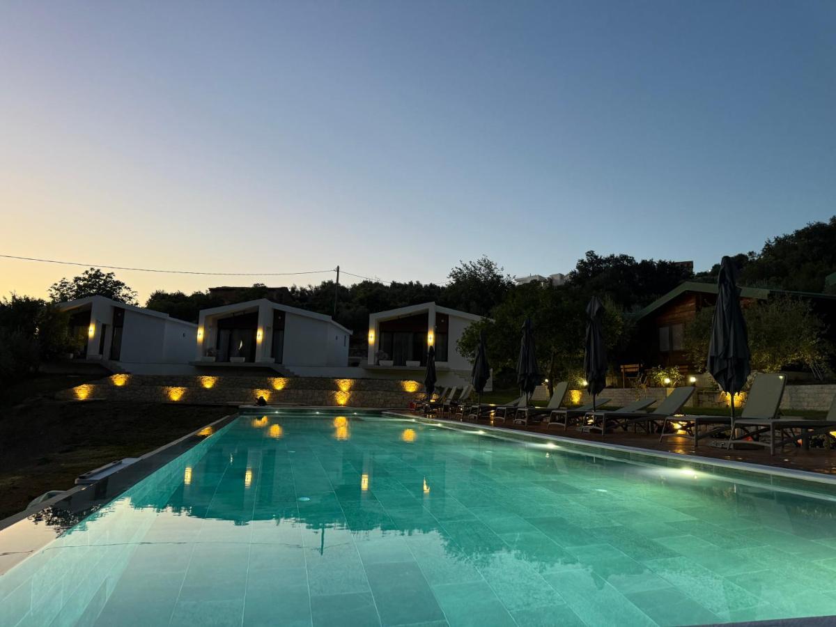 Three white bungalows with lit wall lamps stand at dog-friendly Casa Mila Apartments & Bungalows in Ulcinj.