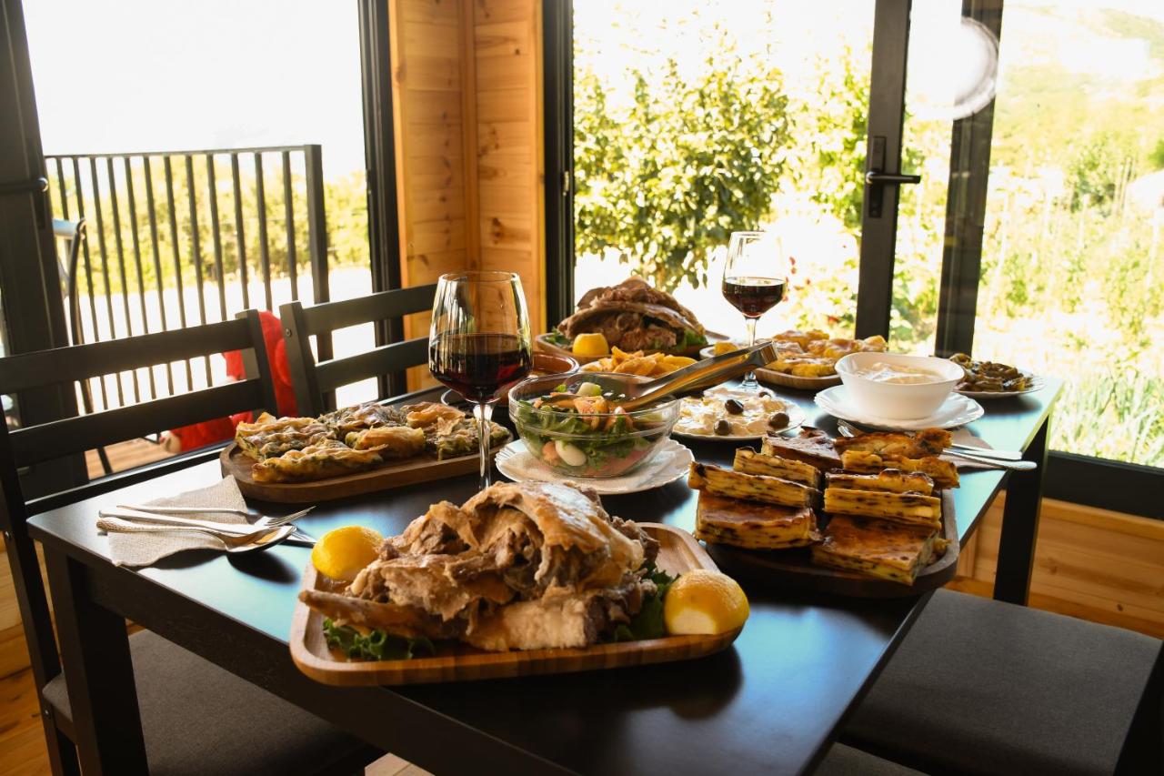 Wooden platter with roasted meat and yellow lemon sits at dog-friendly Vatra Traditional Guesthouse in Tepelenë.