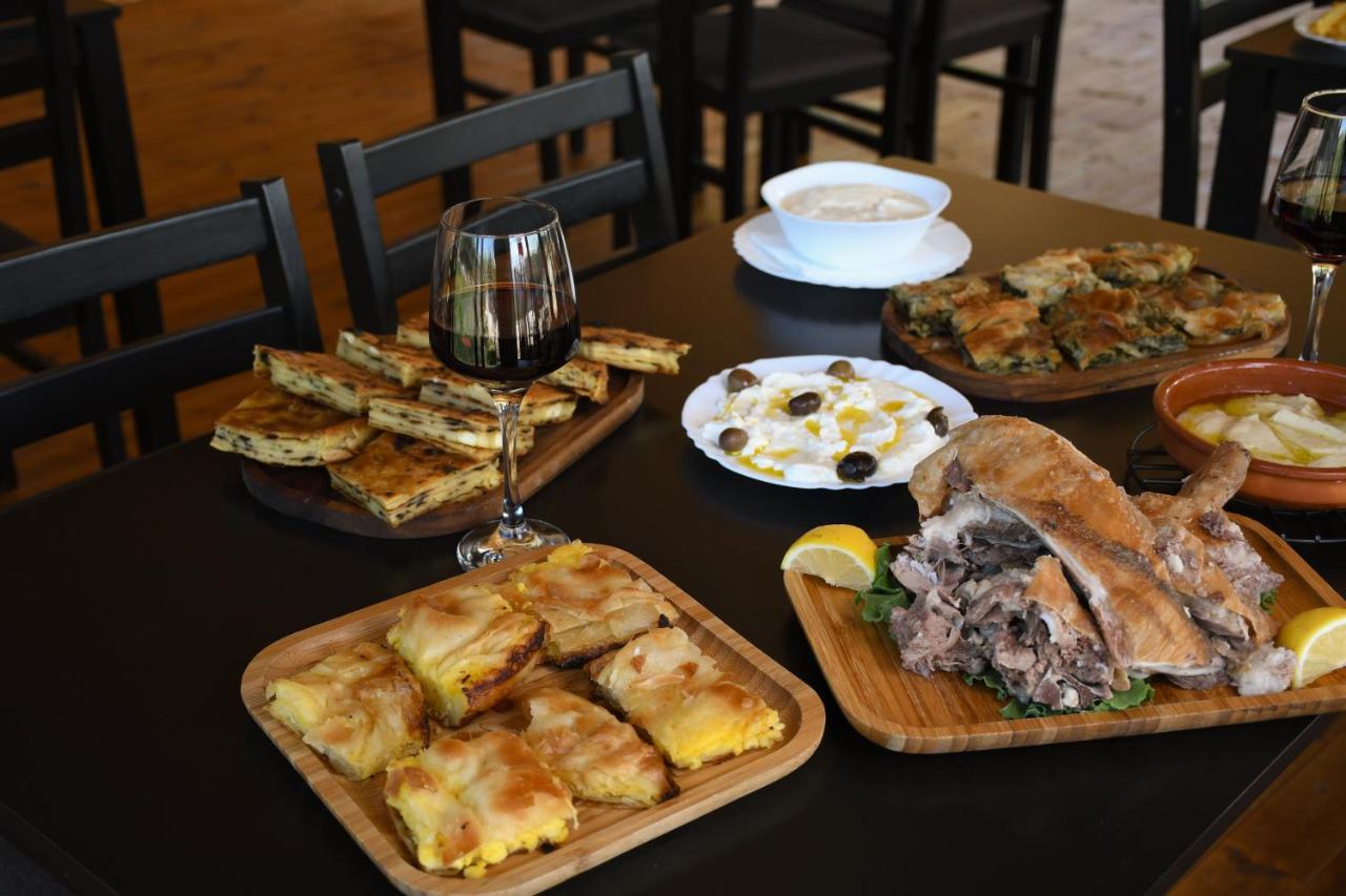 Wooden platter with brown roasted meat and lemon wedges sits at dog-friendly Vatra Traditional Guesthouse in Tepelenë.