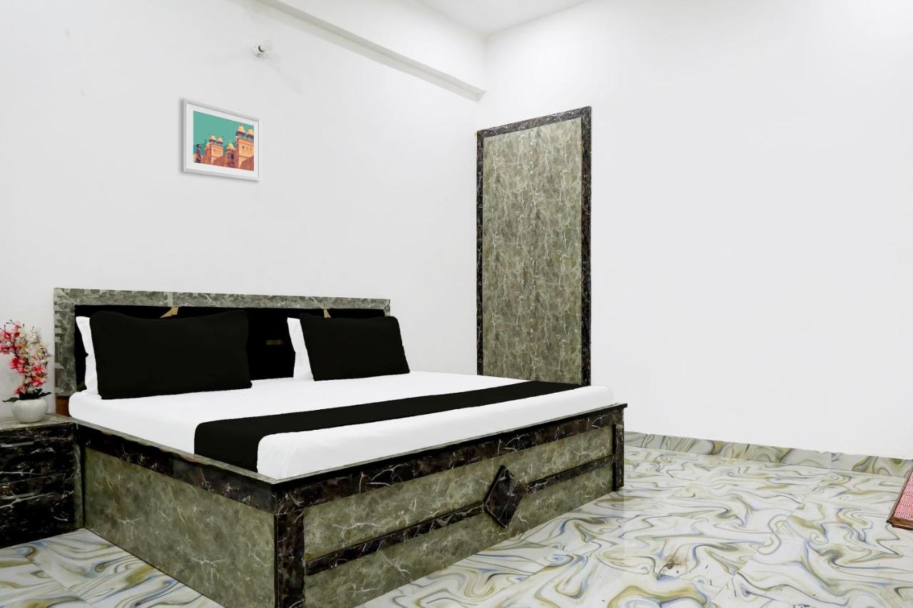 Bed with black pillows and white sheets sits at pet-friendly OYO Hotel Shri Ram Krishna and Resort in Akbarpur.