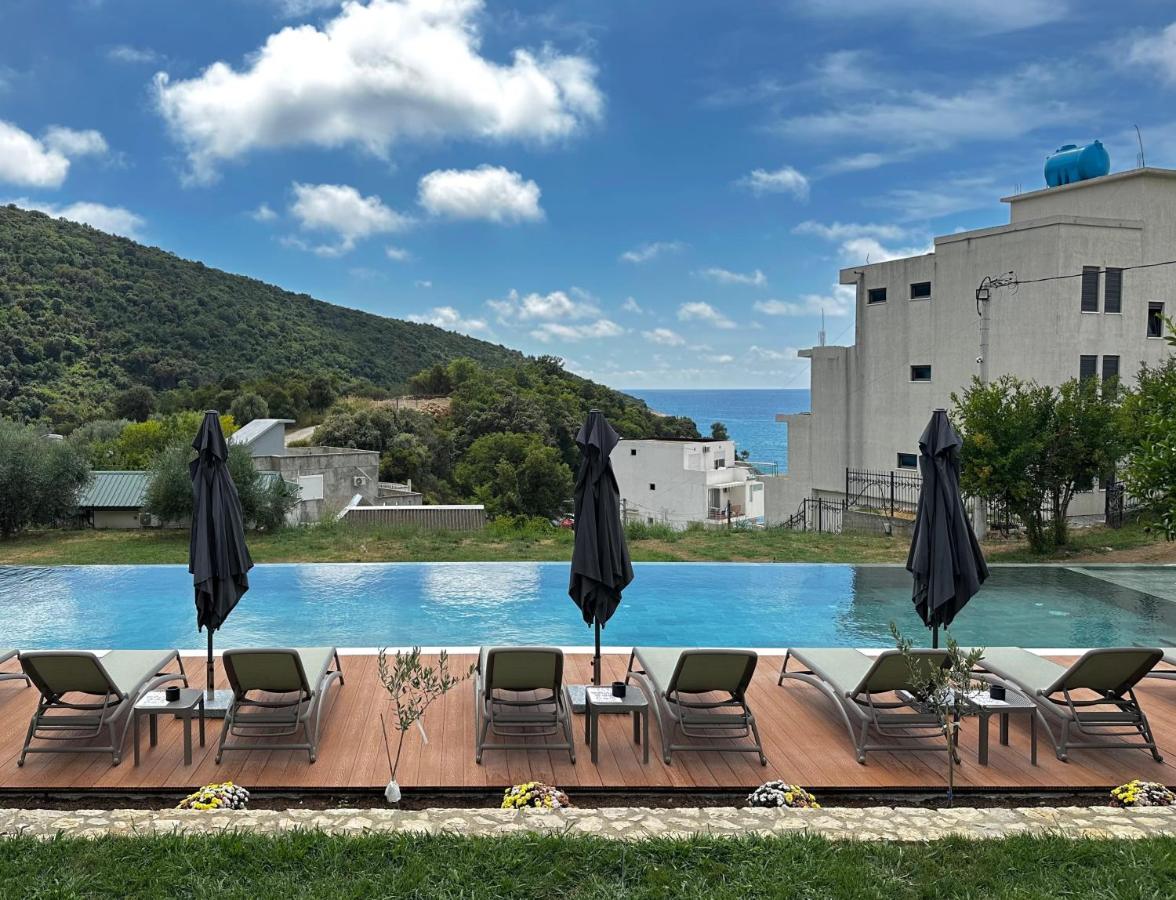 Three gray lounge chairs with green cushions sit on deck at dog-friendly Casa Mila Apartments & Bungalows in Ulcinj.
