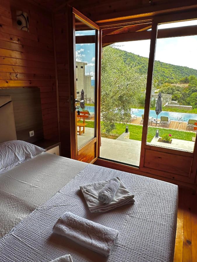 White-sheeted bed with folded white towels faces open glass doors at pet-friendly Casa Mila Apartments & Bungalows in Ulcinj.