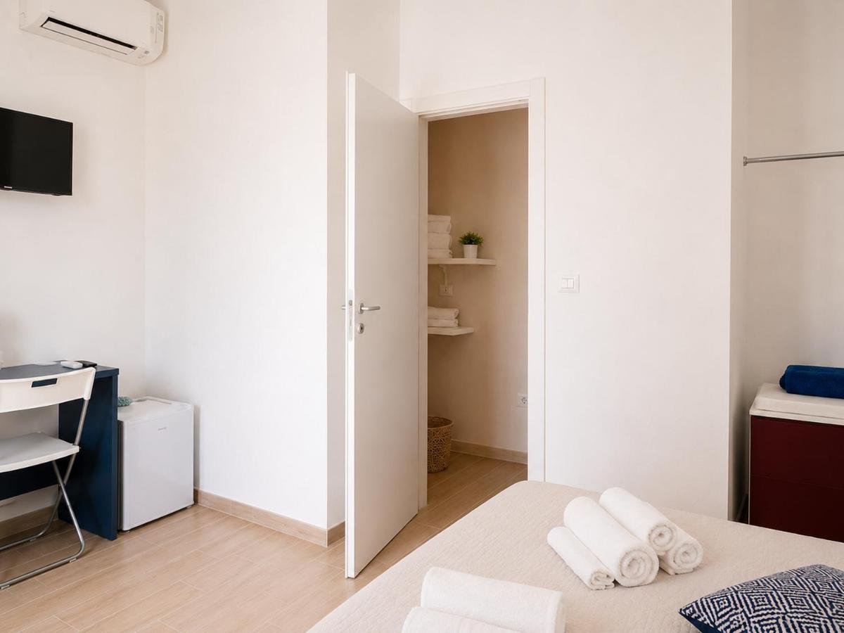 White bed with rolled white towels sits near open door at dog-friendly B&B EVO Nardò in Nardo.
