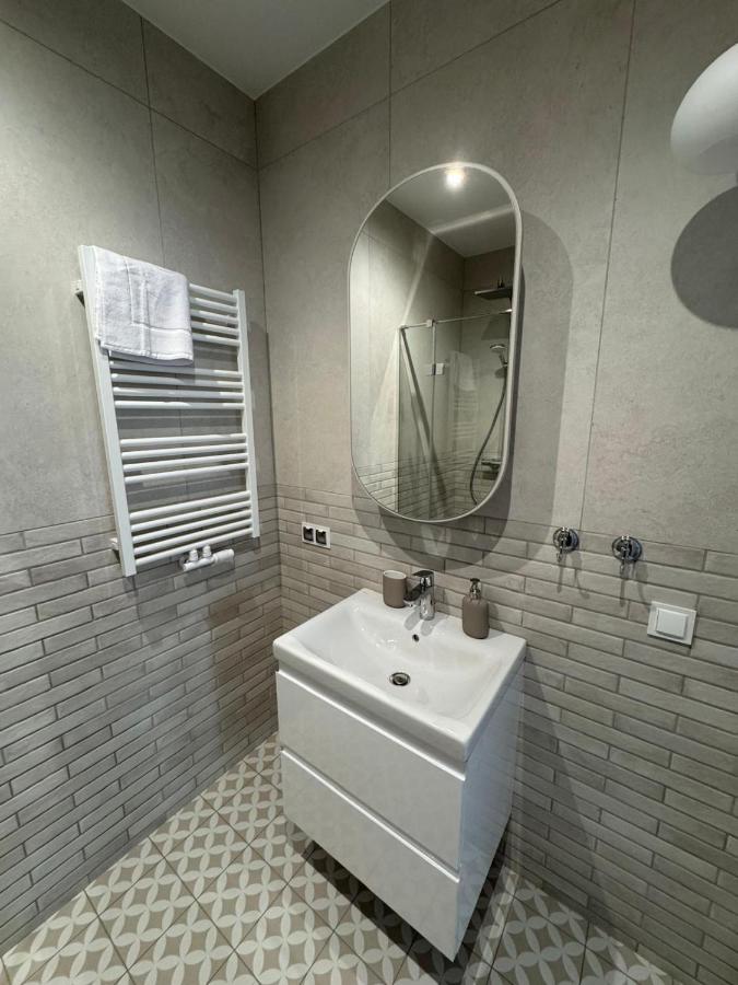 White sink cabinet with oval mirror and towel on radiator stands at dog-friendly Port Rewa in Rewa.