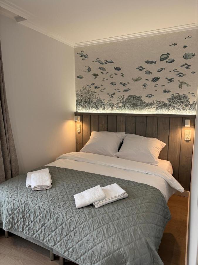 Gray quilted bed with white pillows sits against wooden headboard at dog-friendly Port Rewa in Rewa.