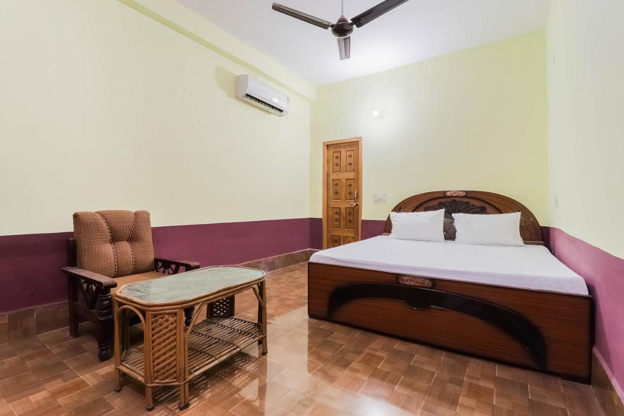 Brown upholstered armchair sits beside rattan table at pet-friendly OYO Hotel 44676 Jyotish House in Ayodhya.