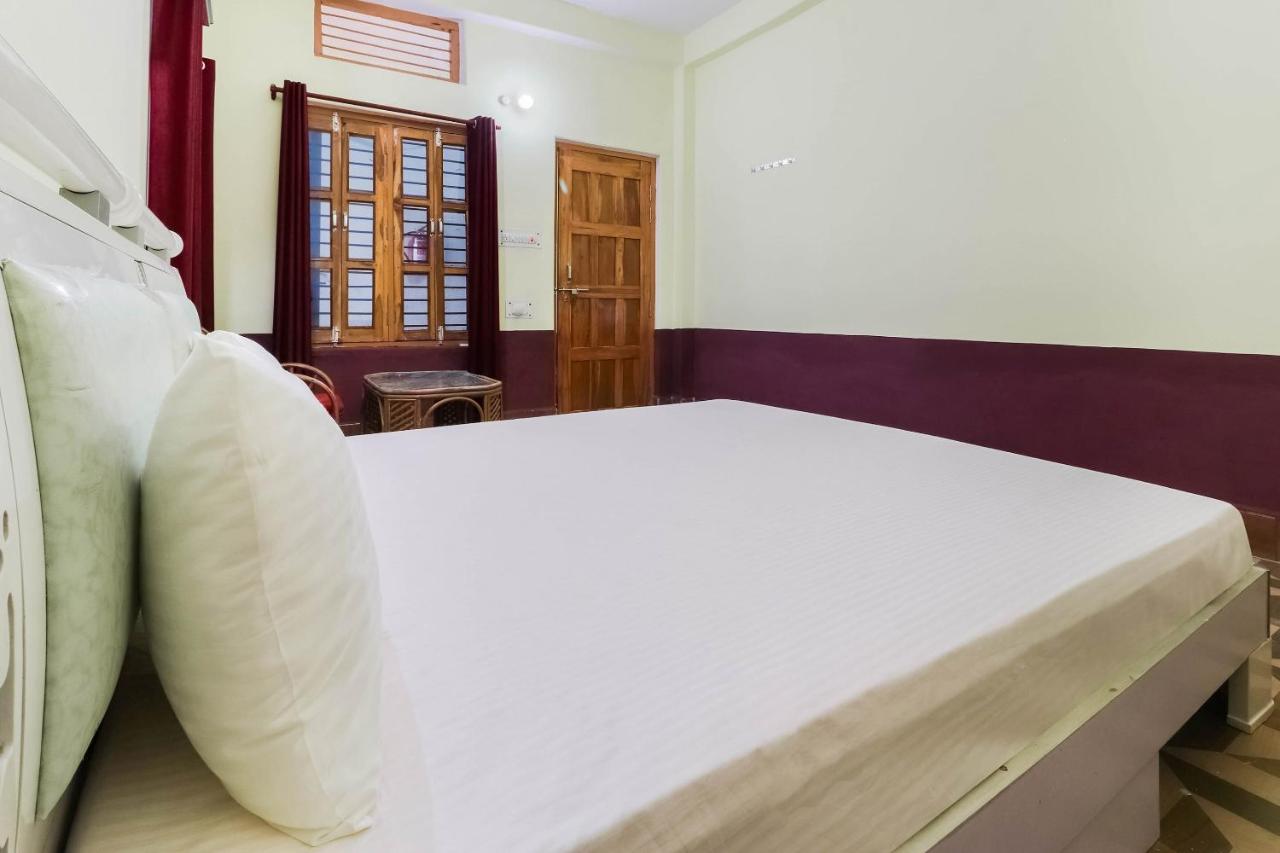 White bed with white pillows sits at dog-friendly OYO Hotel 44676 Jyotish House in Ayodhya.