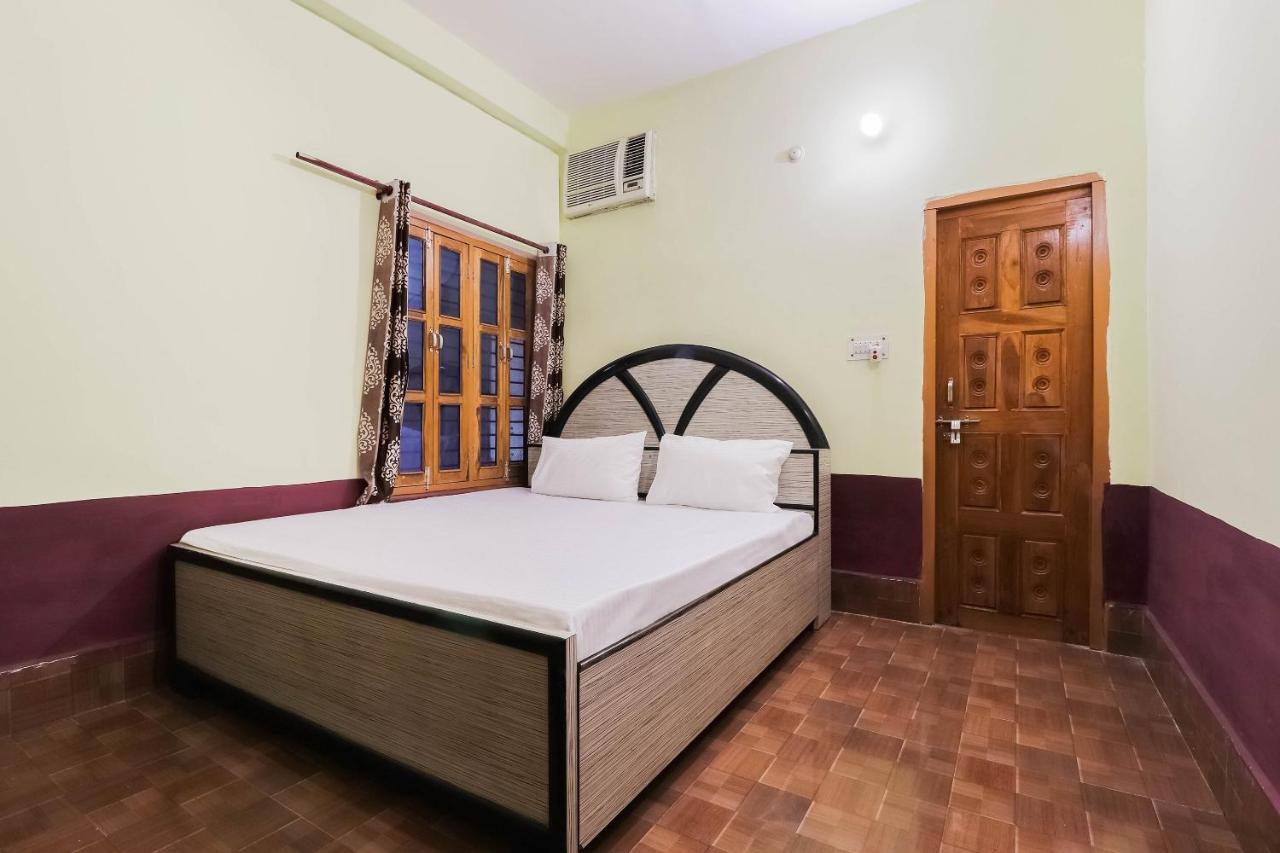 Beige-and-black bed with white pillows sits at dog-friendly OYO Hotel 44676 Jyotish House in Ayodhya.