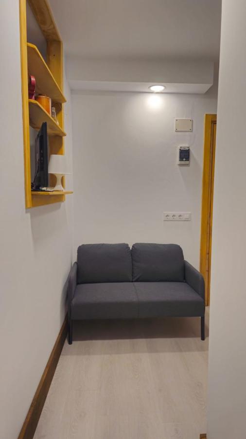 Small gray two-seat sofa sits at dog-friendly JABUTI Autocaravana Con Porche Y Aparcamiento in El Palmar.