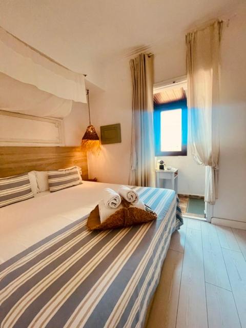 Striped bed with rolled towels sits at dog-friendly Casal d'Artà by Baudot 1926 - Adults Only in Arta.