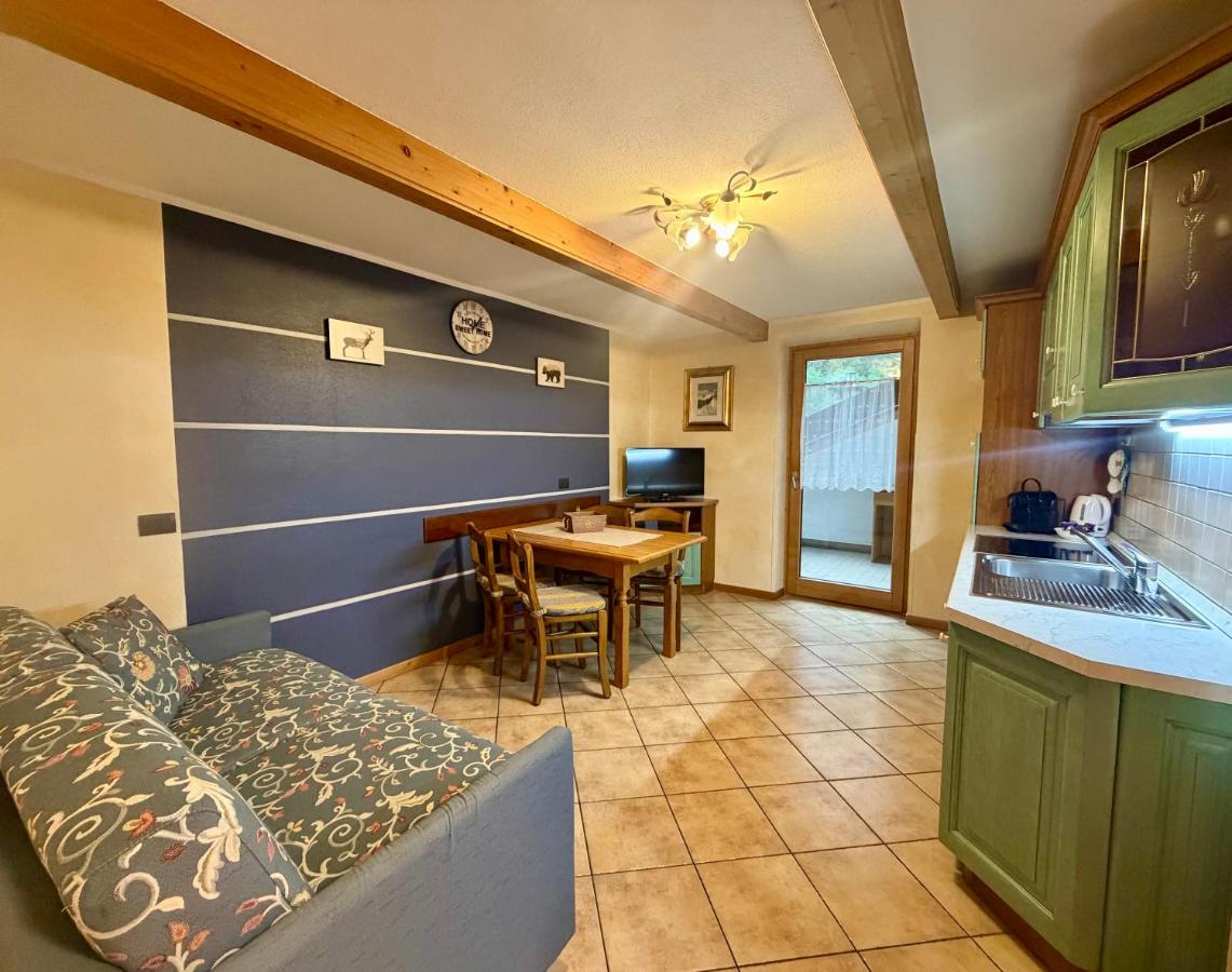 Blue floral sofa and green cabinets sit at dog-friendly Rosengarden Alpine Residence in Valdidentro.
