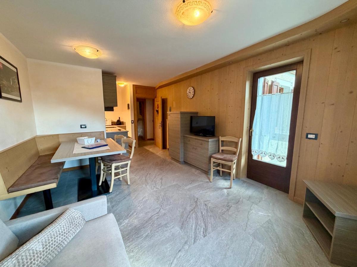 Light wood-paneled room with beige banquette and gray sofa contains table at pet-friendly Rosengarden Alpine Residence in Valdidentro.