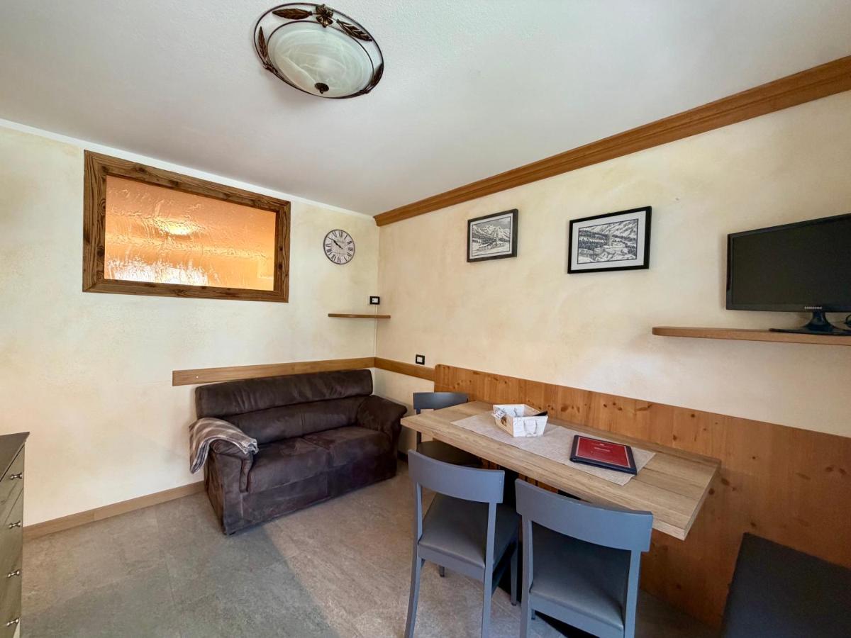 Brown suede sofa with gray throw sits beside wooden table at pet-friendly Rosengarden Alpine Residence in Valdidentro.
