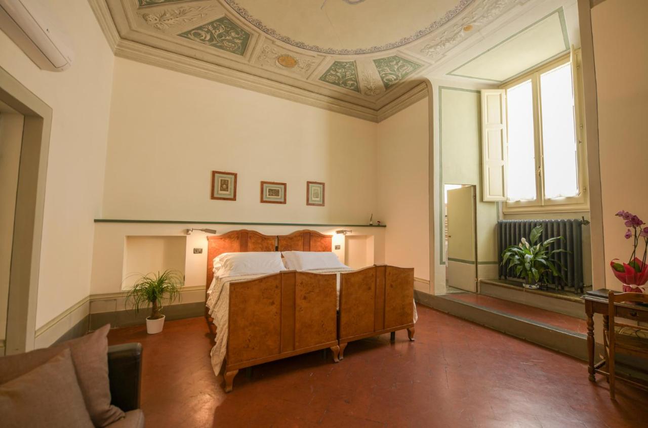 Wooden double bed with white sheets sits at dog-friendly Casa Rovai Guest House in Florence.