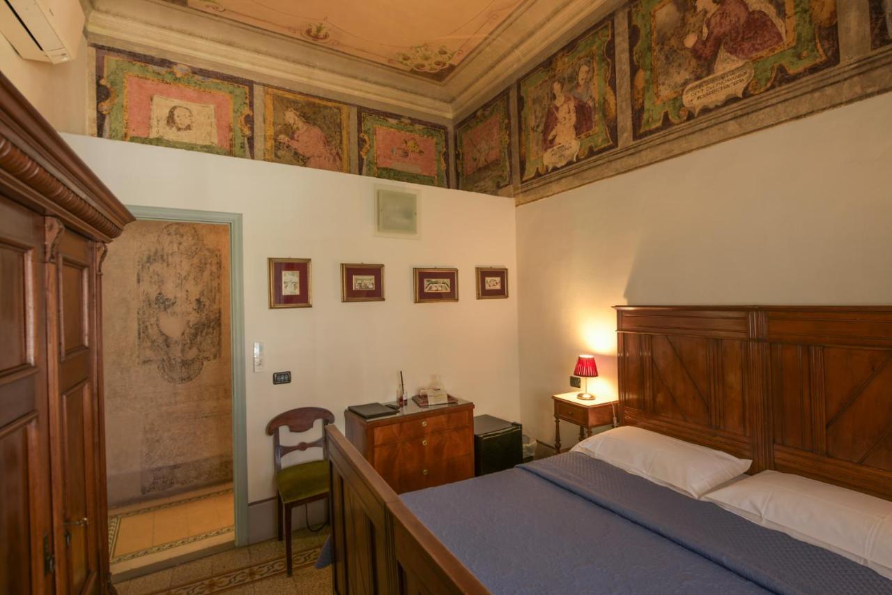 A wooden bed with blue bedspread and white pillows sits at dog-friendly Casa Rovai Guest House in Florence.