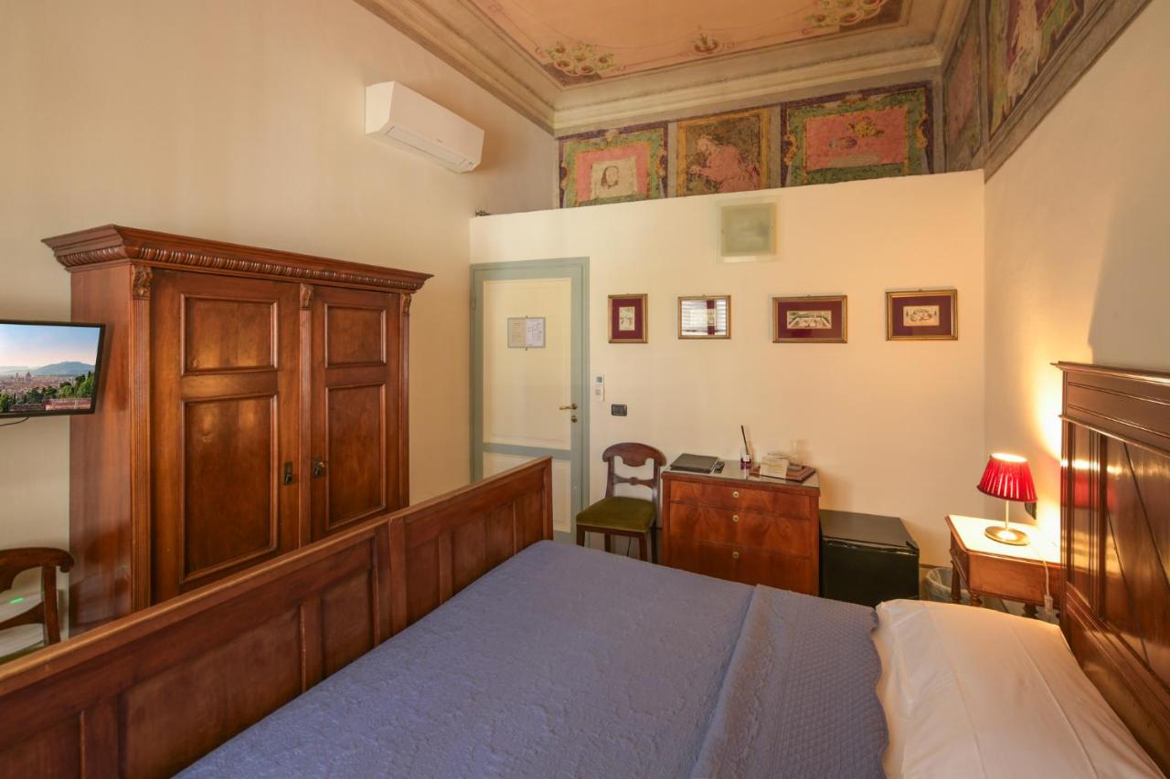Wooden bed with blue quilt sits at dog-friendly Casa Rovai Guest House in Florence.