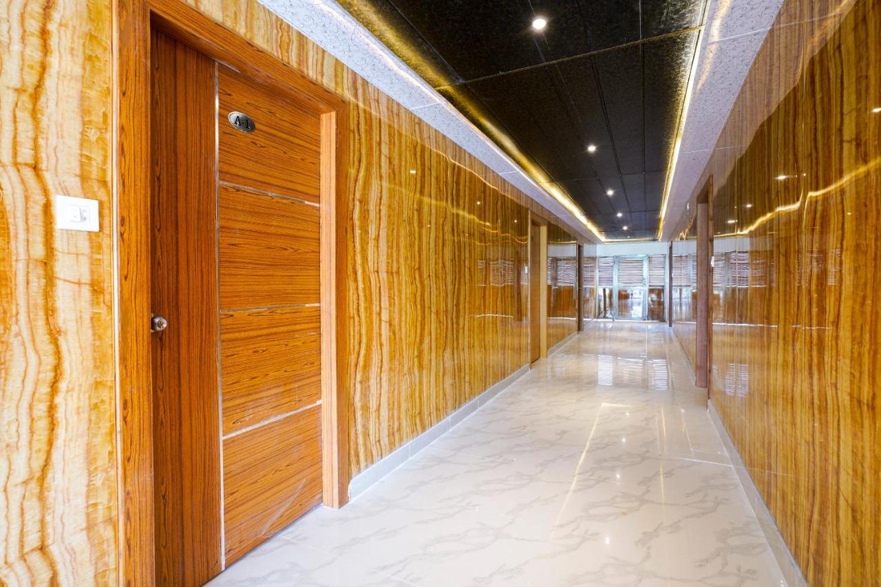 Wood-paneled hallway with white marble floor extends at pet-friendly Hotel O Raghavendra Residency in Warangal.